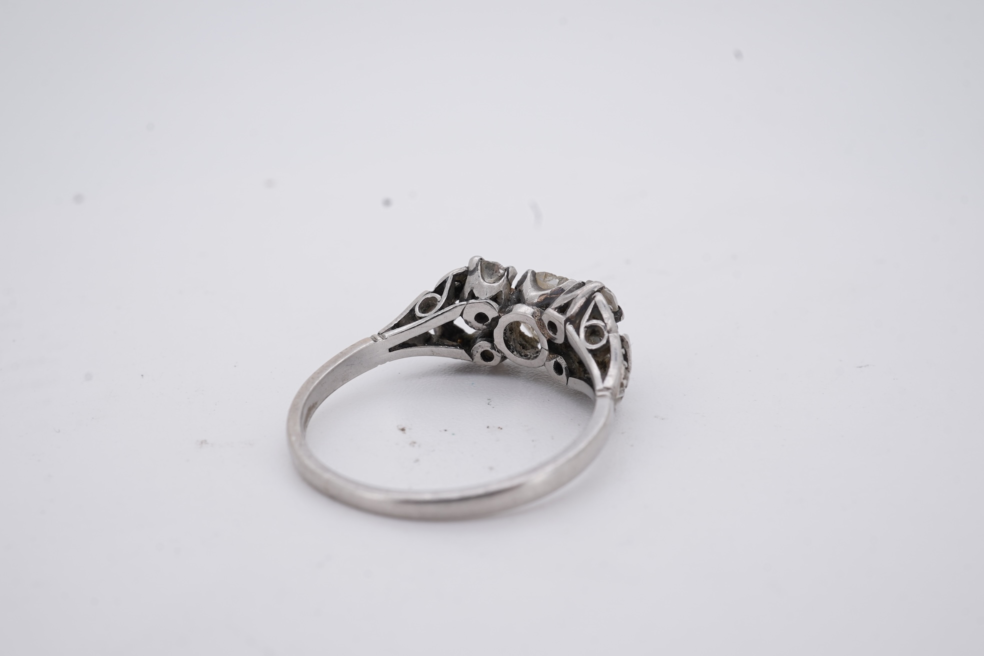 A white metal (stamped platin) and single stone diamond ring, flanked by four smaller diamonds and rose cut diamond chip set shoulders, size P, gross weight 3.8 grams.
